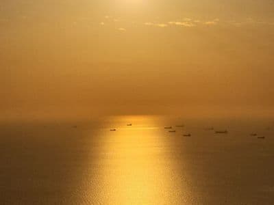 Golden sunset over calm bay with boats