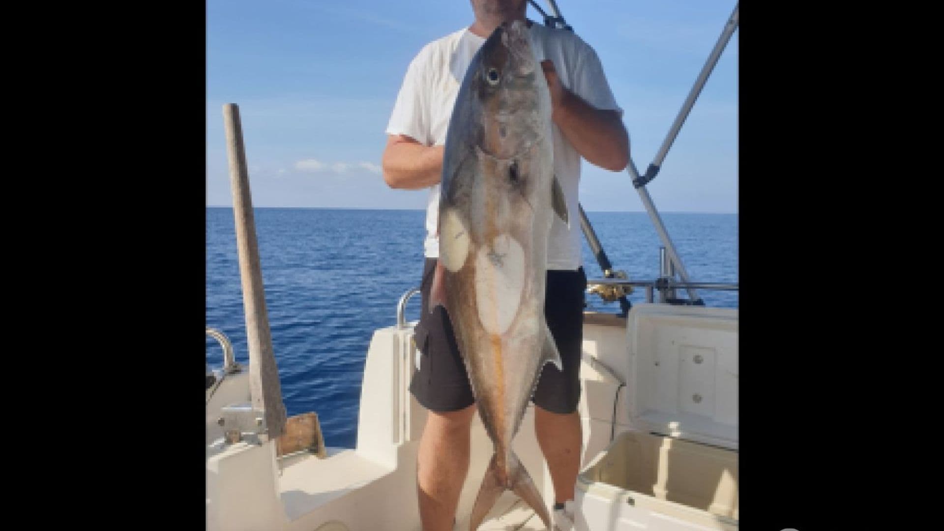 Gost pokazuje krupnu ulovljenu ribu na brodu